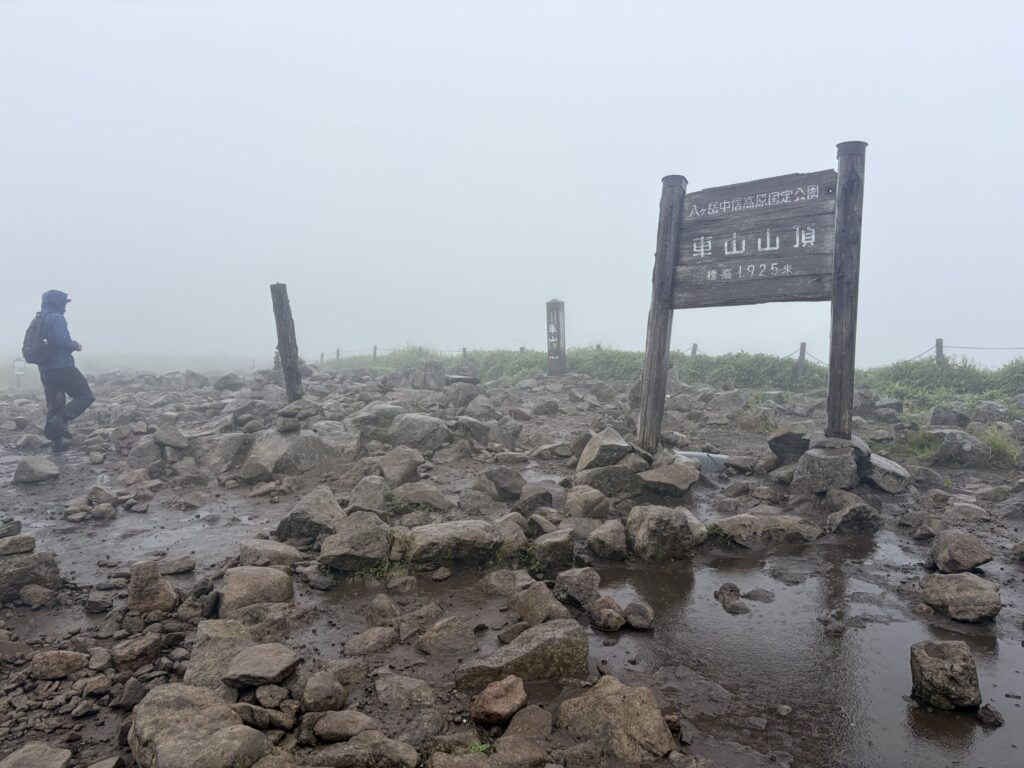 車山山頂標識とレインウェア姿のパパ
